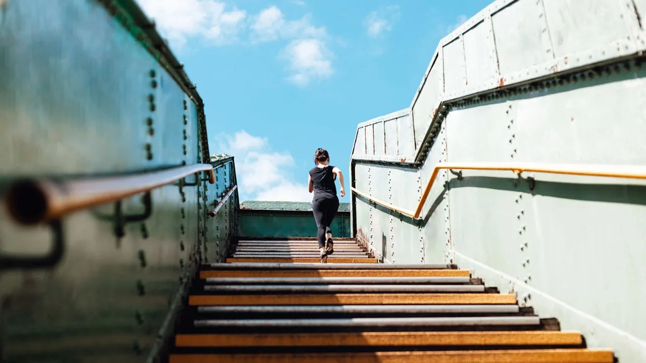 Runner climbing a long outdoor staircase