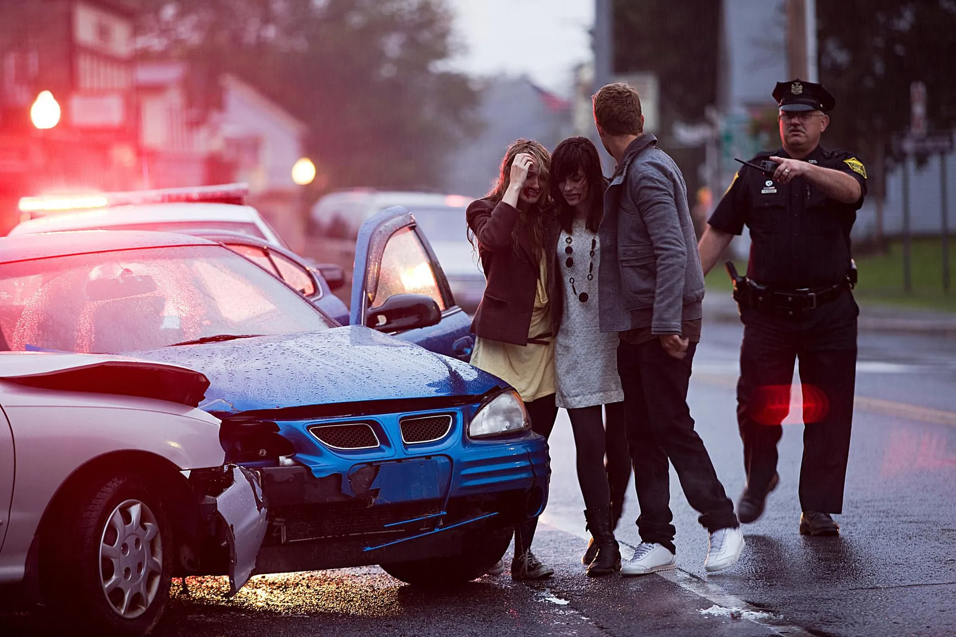 Family standing near a crashed car with a police officer