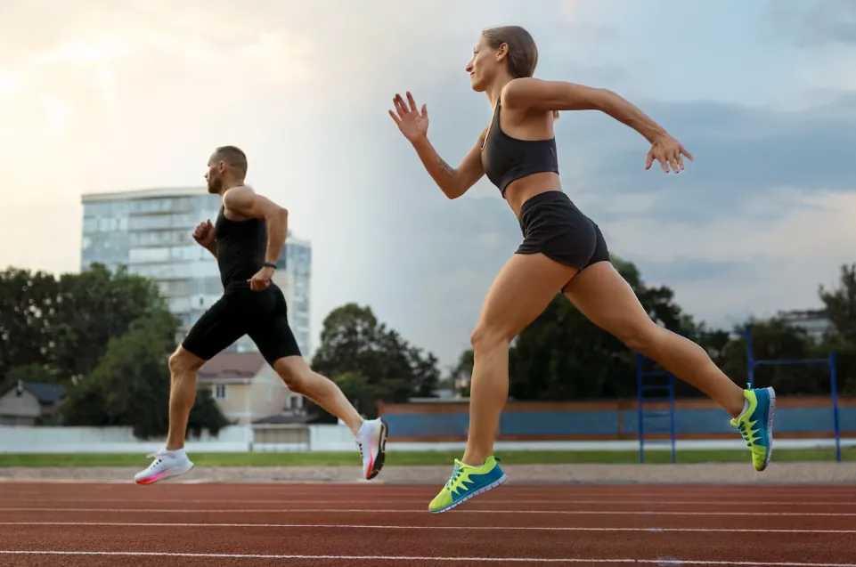 Man and woman sprinting on a running track