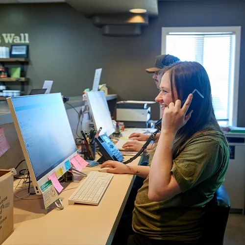 Front desk team member on the phone at a computer