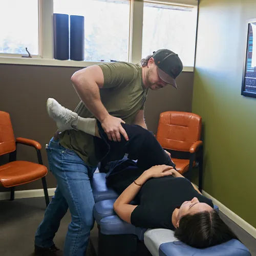 Chiropractor flexing a patient's leg during treatment