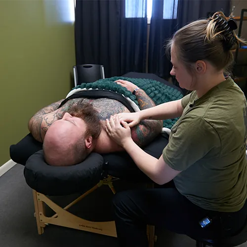 Massage therapist performing lymphatic drainage on a patient's shoulder