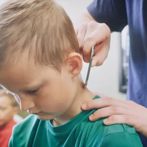 Practitioner using a tool on a child's neck and shoulder
