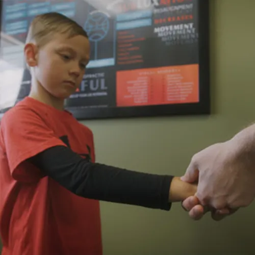 Young boy having his wrist held during a pediatric exam