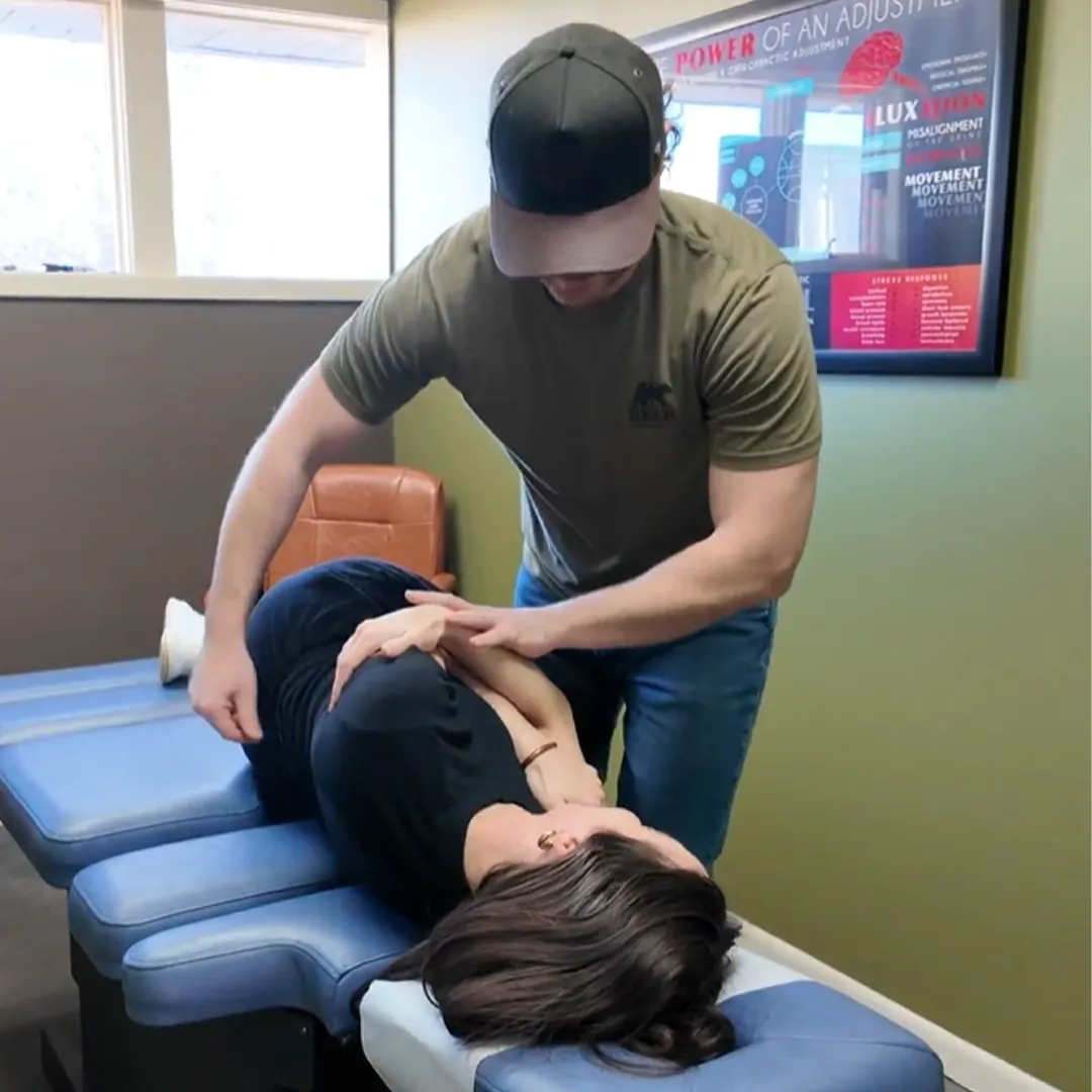 Chiropractor adjusting a patient lying on her side