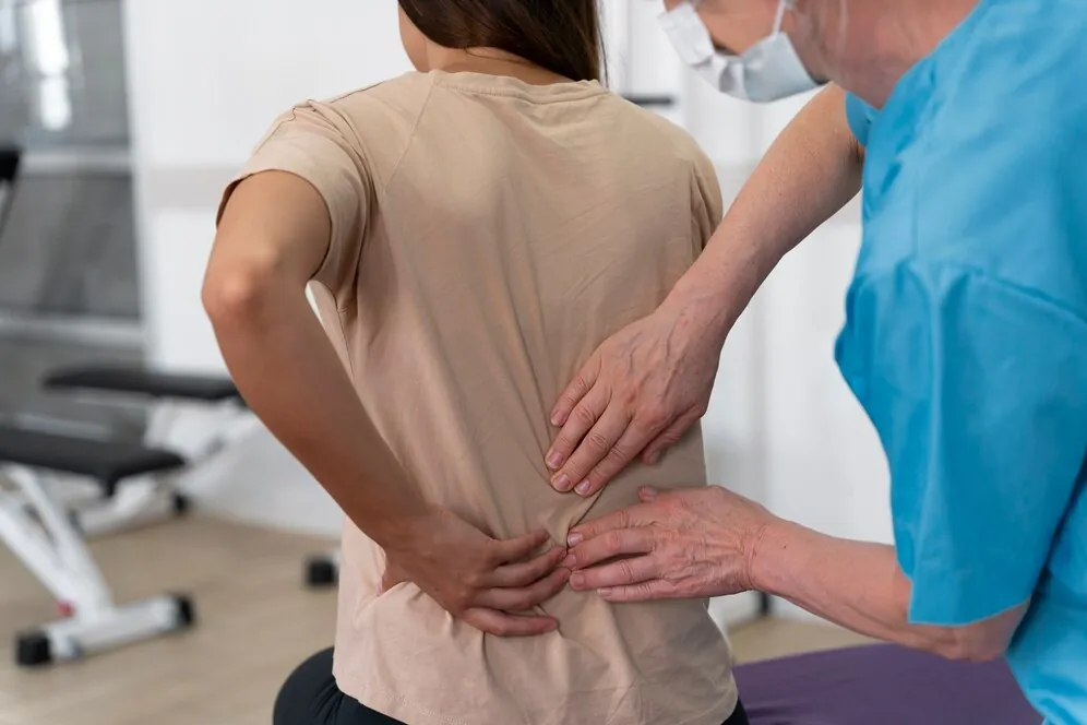 Clinician checking a patient's lower back