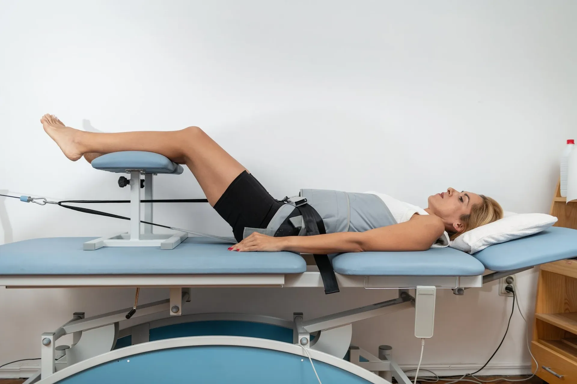 Woman lying on a decompression table with legs raised on a support