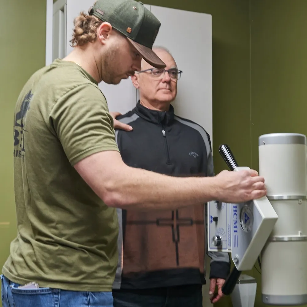 Chiropractor positioning a standing patient at an x-ray unit