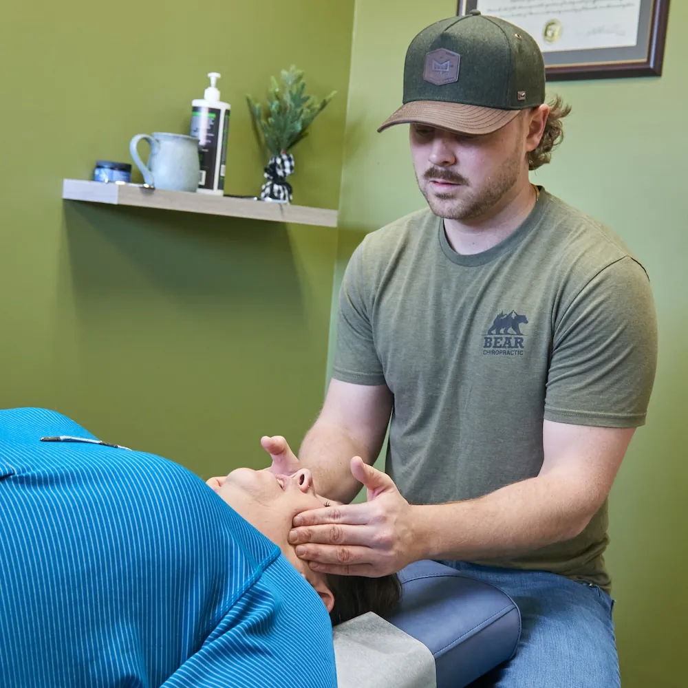 Dr. Aaron Zimmerman treating a patient's jaw on a treatment table