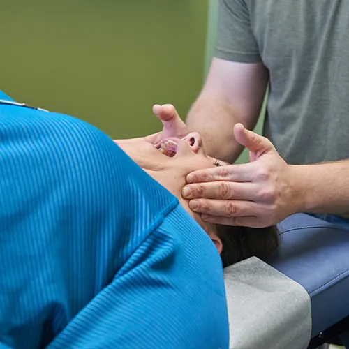 Close-up of Dr. Aaron Zimmerman's hands treating a patient's jaw