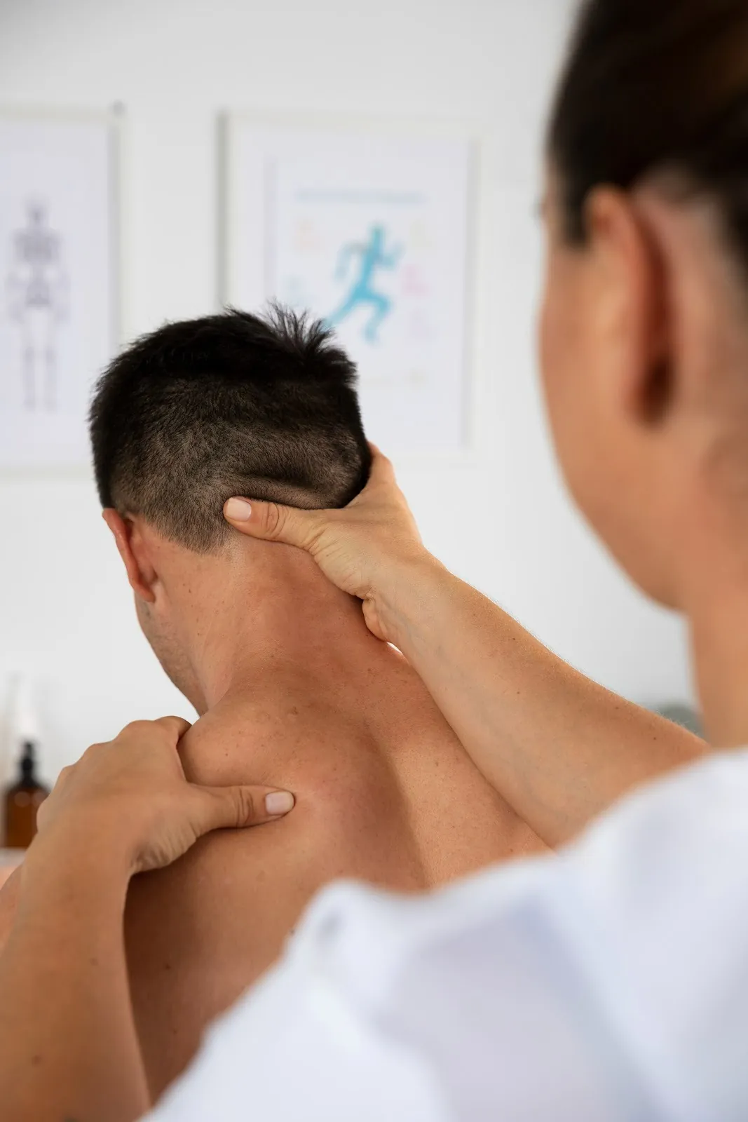 Therapist examining a man's neck and shoulder