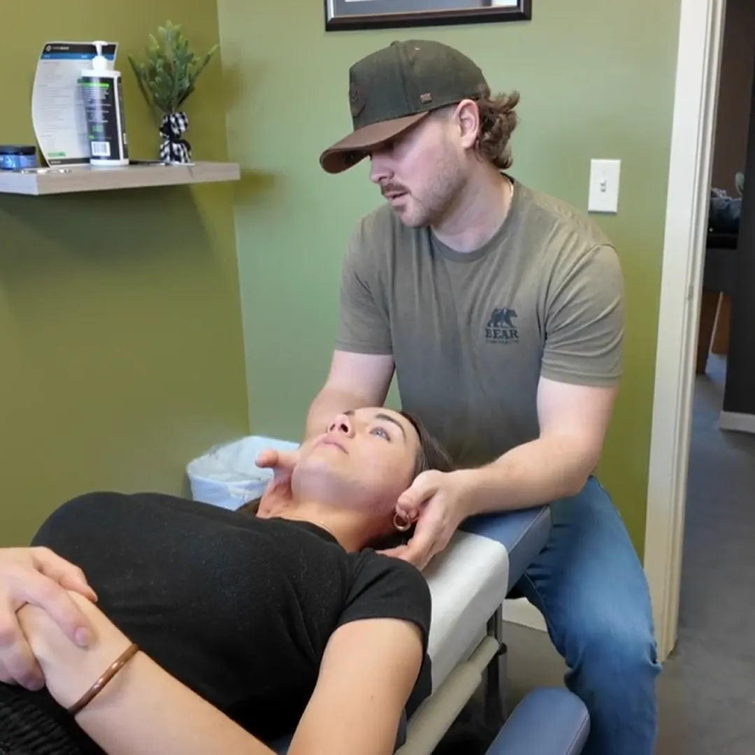 Chiropractor adjusting the neck of a patient lying on a table